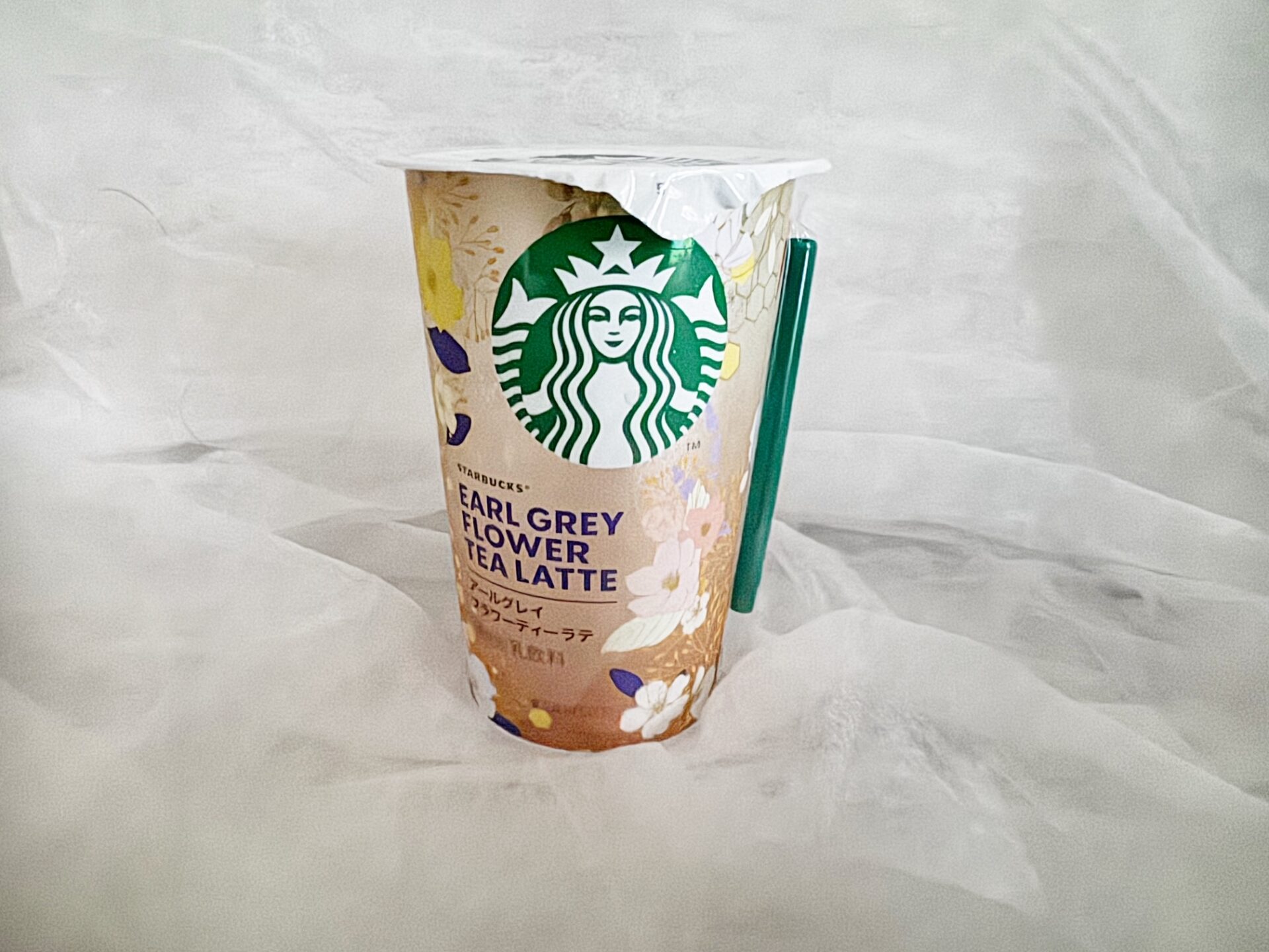 スターバックスチルドカップ アールグレイフラワーティーラテの商品写真。こがねいろにいろづきはじめる秋をイメージしたゴールドをベースに、うっすらピンクがかったメタリック調のふうあいが華やかなデザインです。本体上部にはスターバックスのロゴがあしらわれています