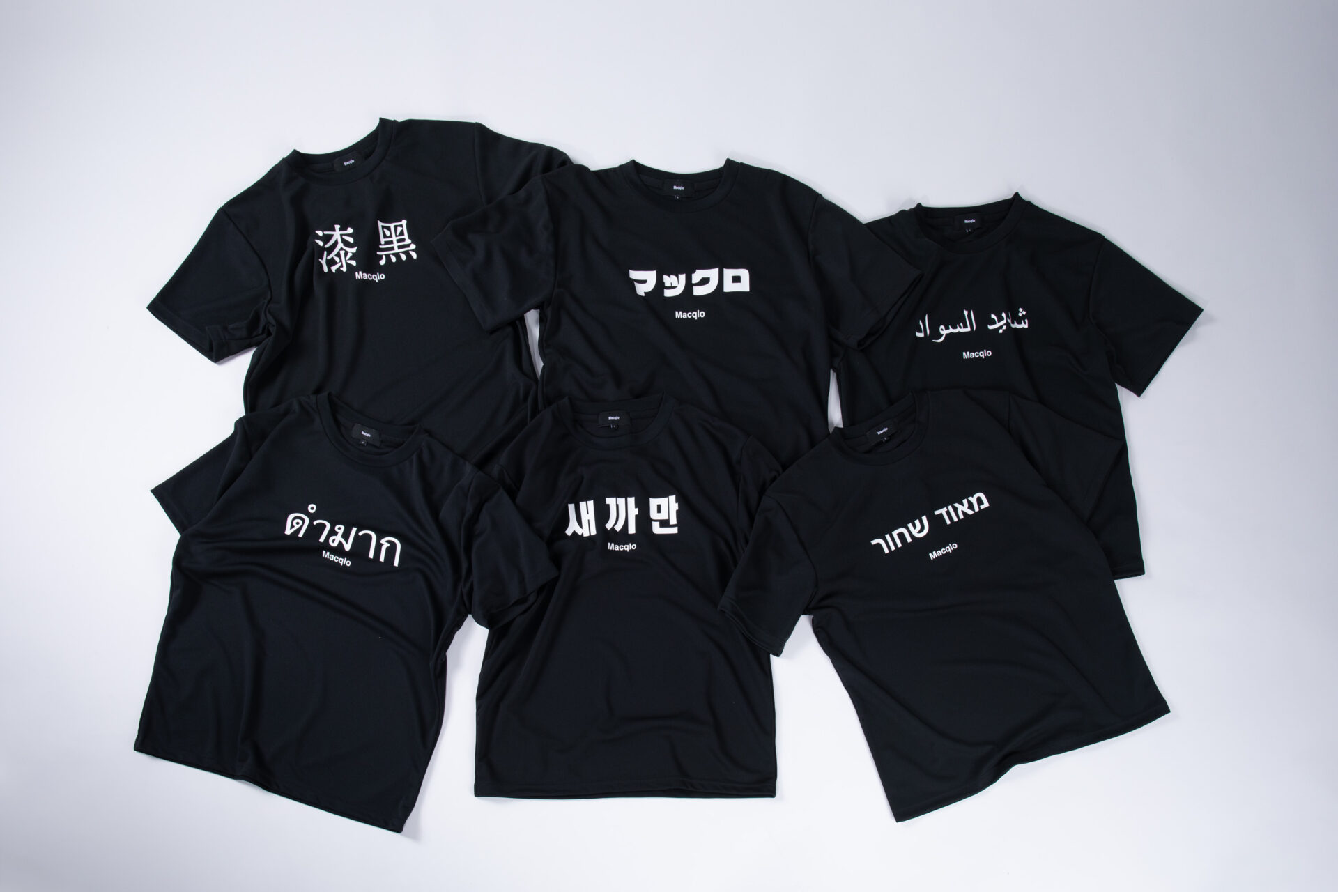 まっくろなハンソデのTシャツに、白の文字で日本語を含む６つのくにの言語で「マックロ」という意味をあらわすたんごがそれぞれ書かれた6種類のTシャツの写真