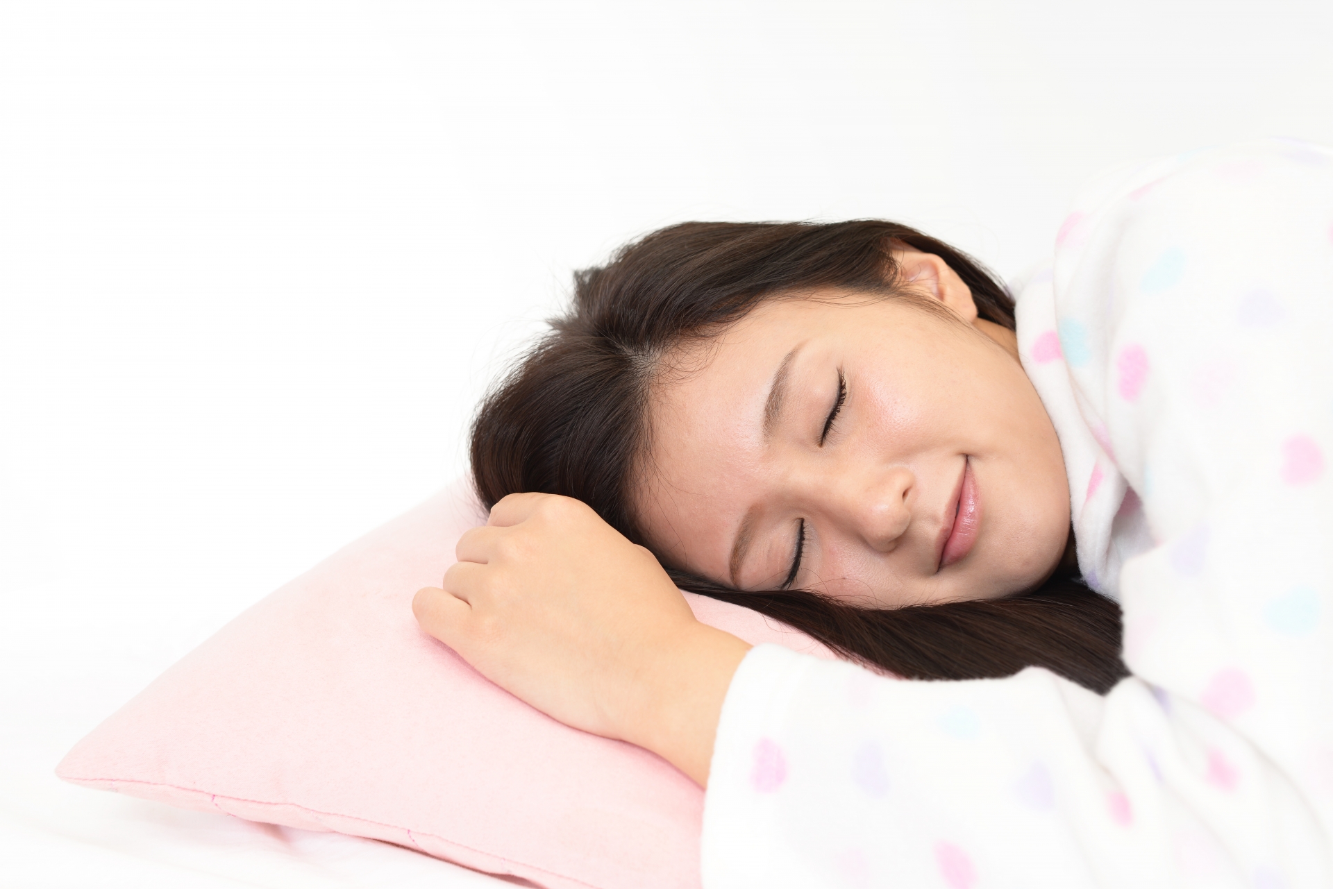 枕で熟睡する女性の横顔の写真